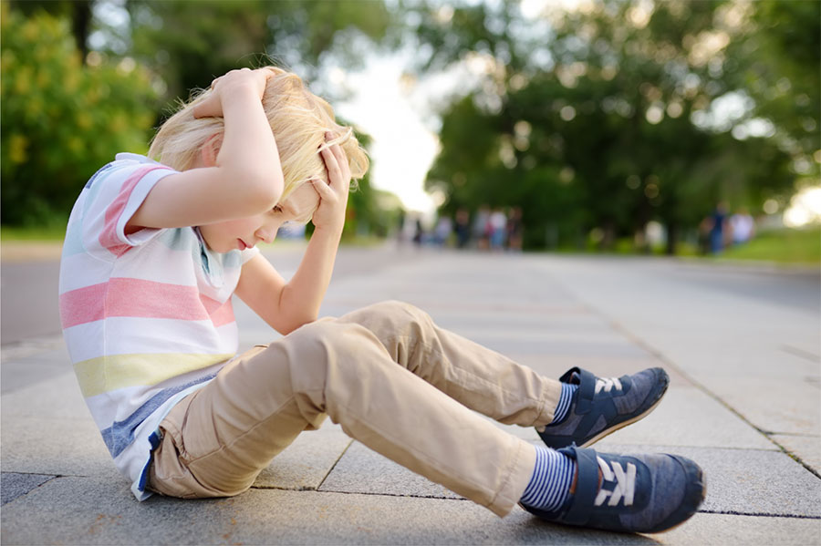 Concussion Cases photo of boy with hands on head